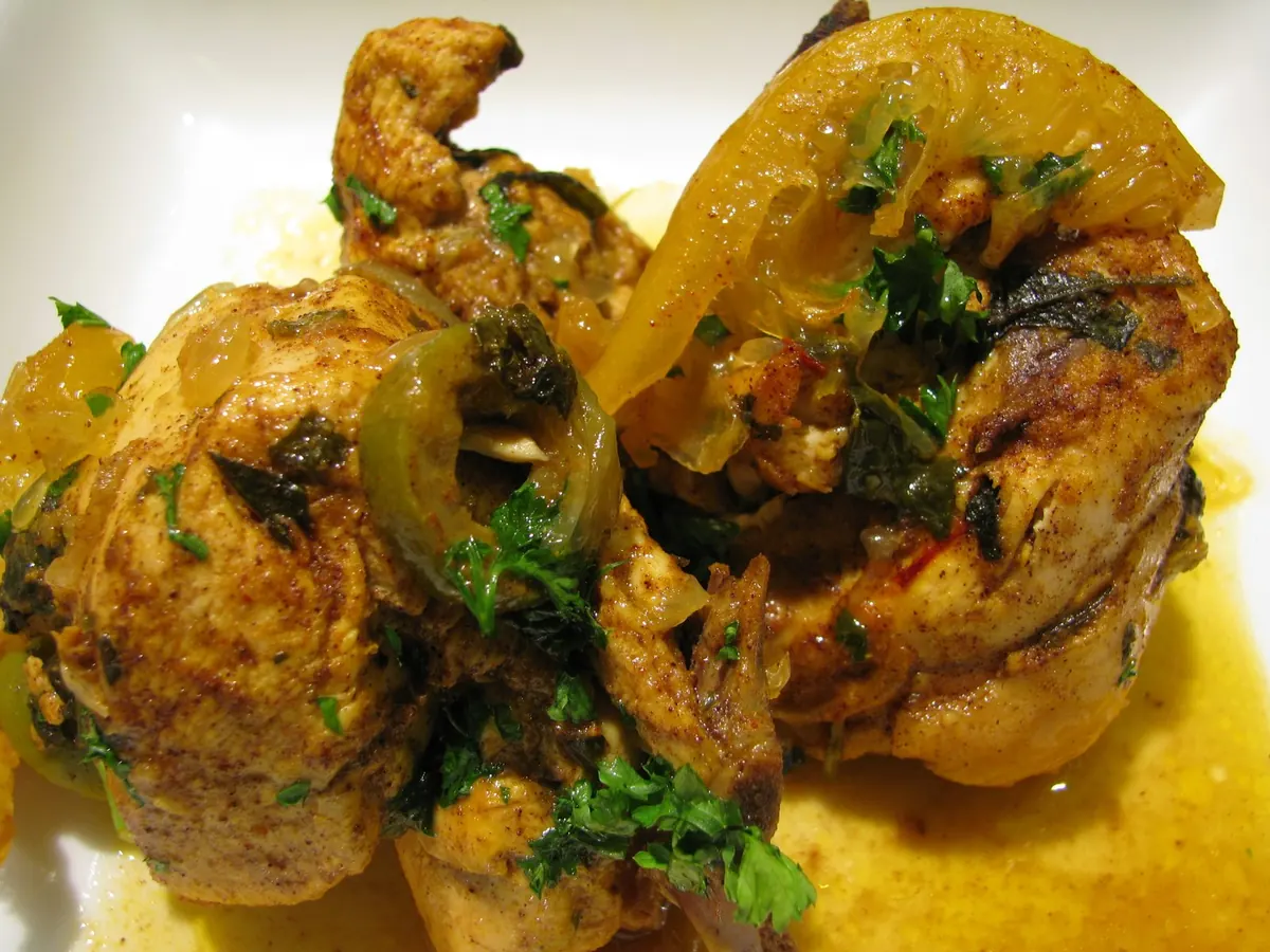 Chicken tagine with preserved lemons and olives; served on a plate.