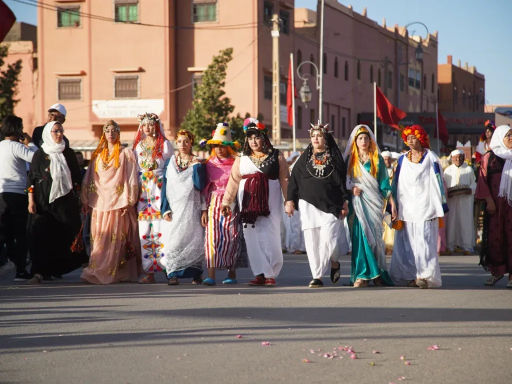A street parade with participants in traditional dress during the rose festival.