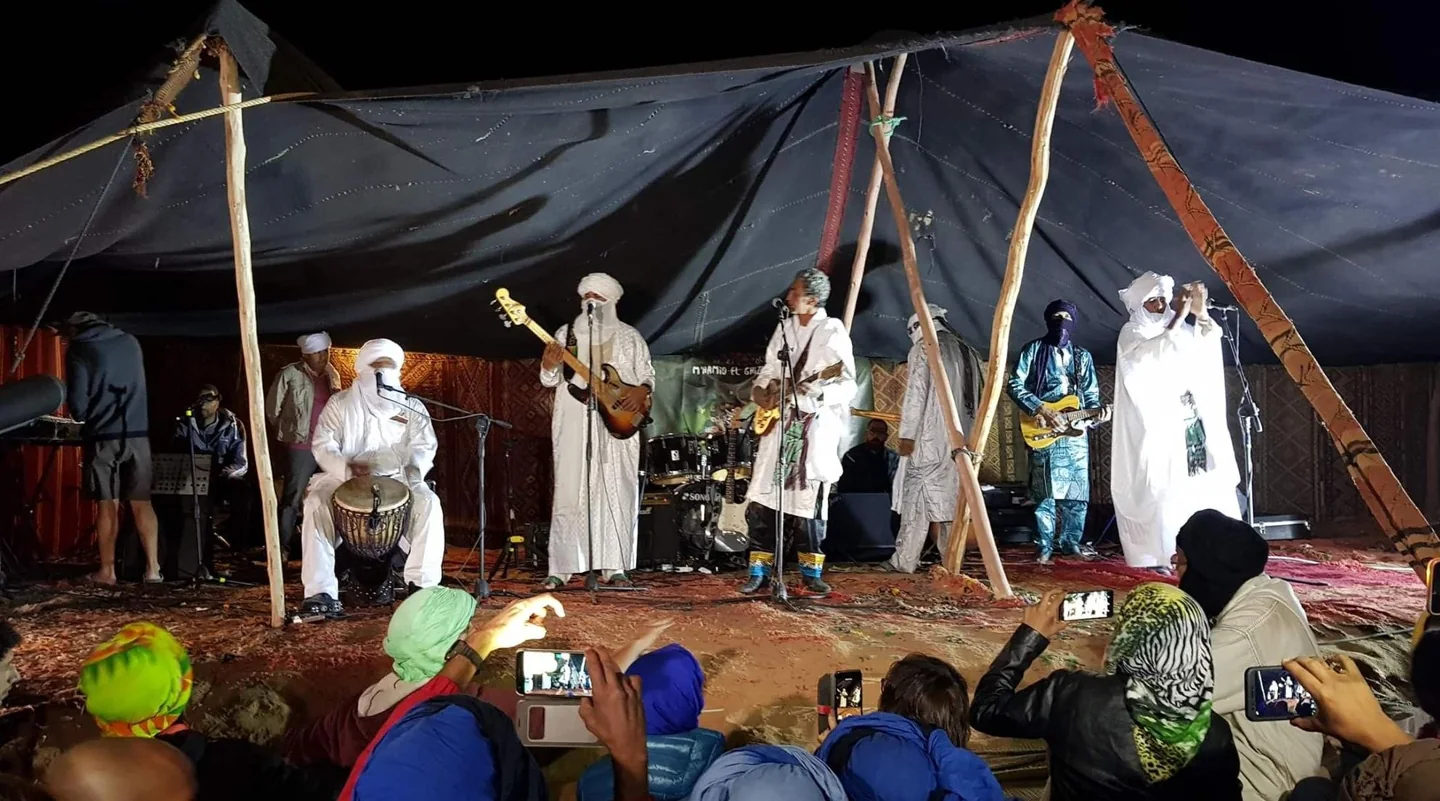 Saharan musicians performing beneath a tent at Taragalte Festival.