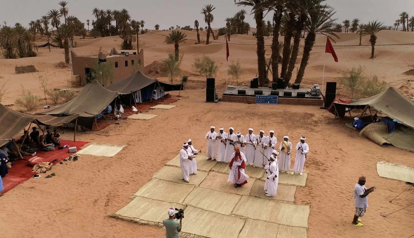 Musicians performing outdoors at the Zamane Festival site in M’Hamid.