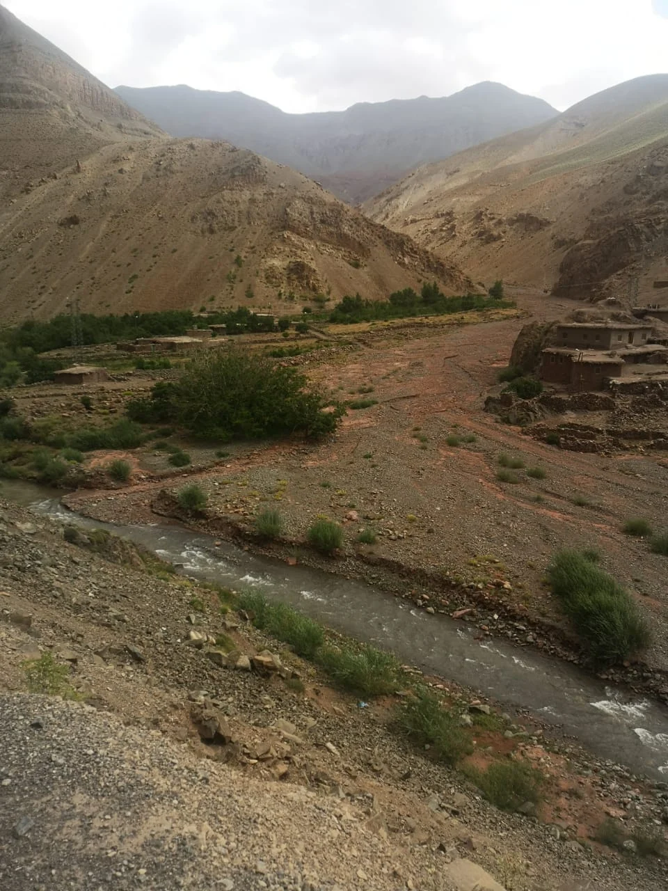 River and earthen buildings beneath the mountains at Ichbaken