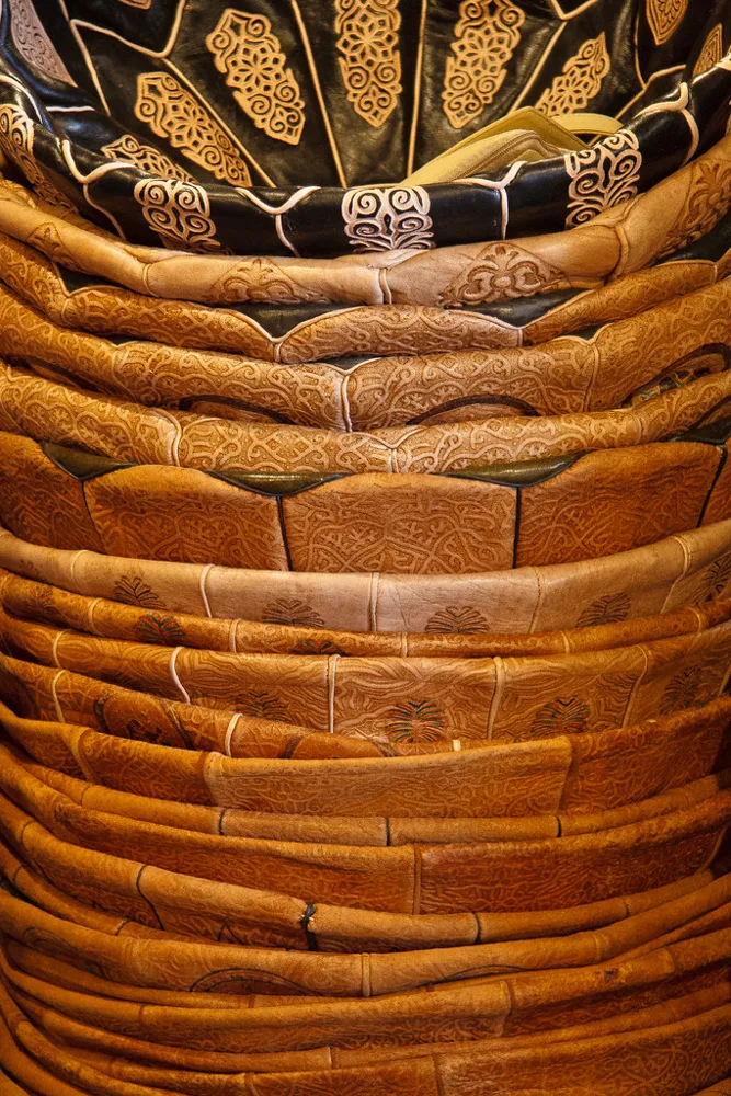 Leather poufs stacked in a Moroccan leather shop