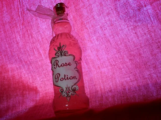 Bottle of homemade rosewater on a pink cloth