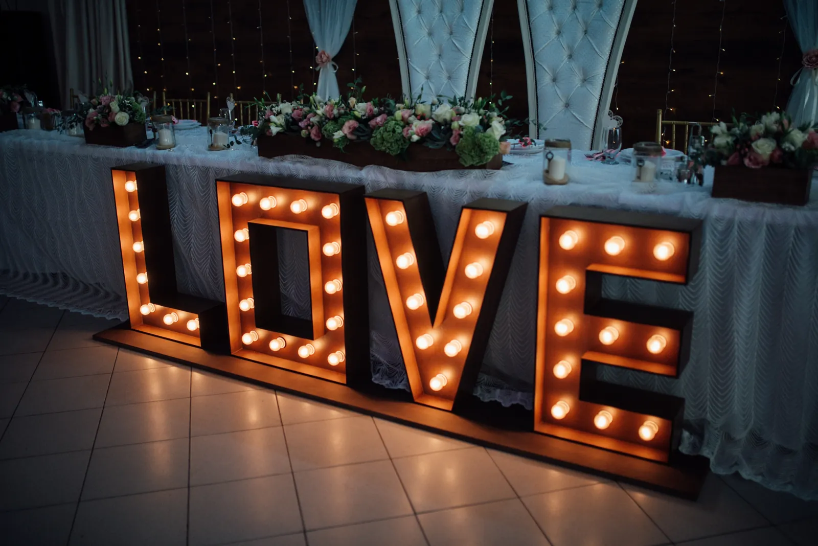 Illuminated LOVE decoration with flowers and ceremonial seating